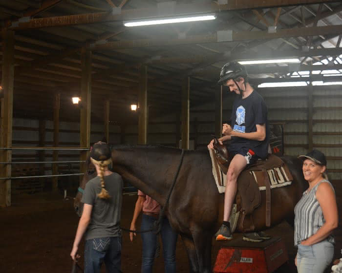 Ethan Starr pumps his fist after playing a game while on horseback at Harmony Ranch.