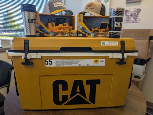 The gift set includes two stylish hats, two radio-controlled tractors, two durable coffee tumblers, and a large heavy-duty ice chest.  Valued at $737